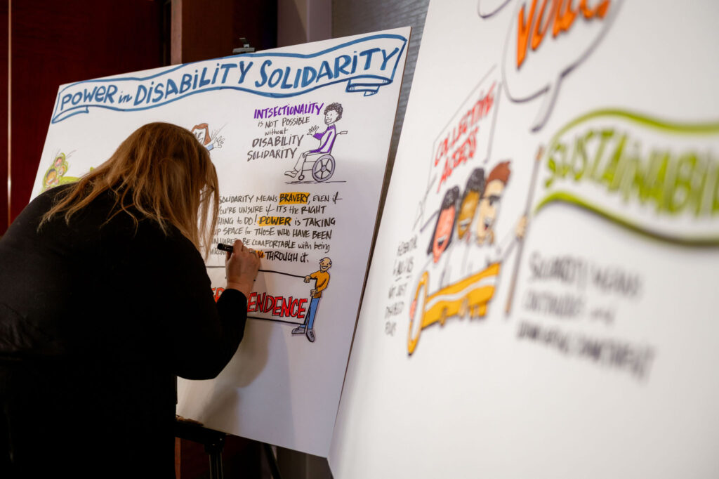 Graphic facilitator Kelly Adams creating a graphic on Power in Dis ability Solidarity.