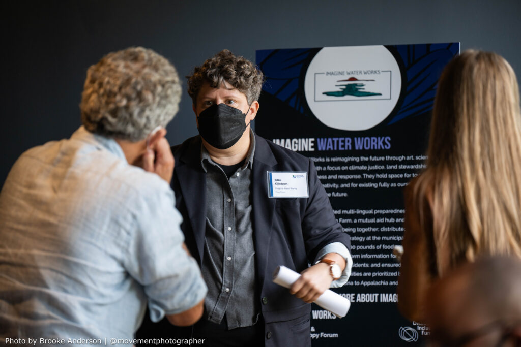 Klie Kliebert speaks to two attendees about Imagine Water Works during the 2025 Presidents' Council Meeting.