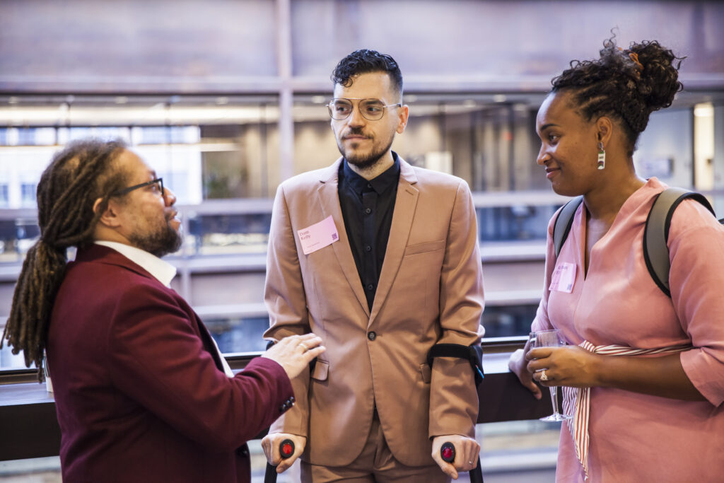 Dom Kelly and Kehsi Iman Wilson, Co-Directors of New Disabled South, talk with Patrick Cokley of the Robert Wood Johnson Foundation at the 2023 Presidents' Council Meeting.
